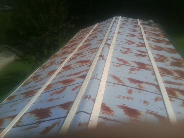 Rusted metal roof panels with new wood purlins before replacement — Storm Damage Roof Repair in Pacific Junction by Roofing Brothers