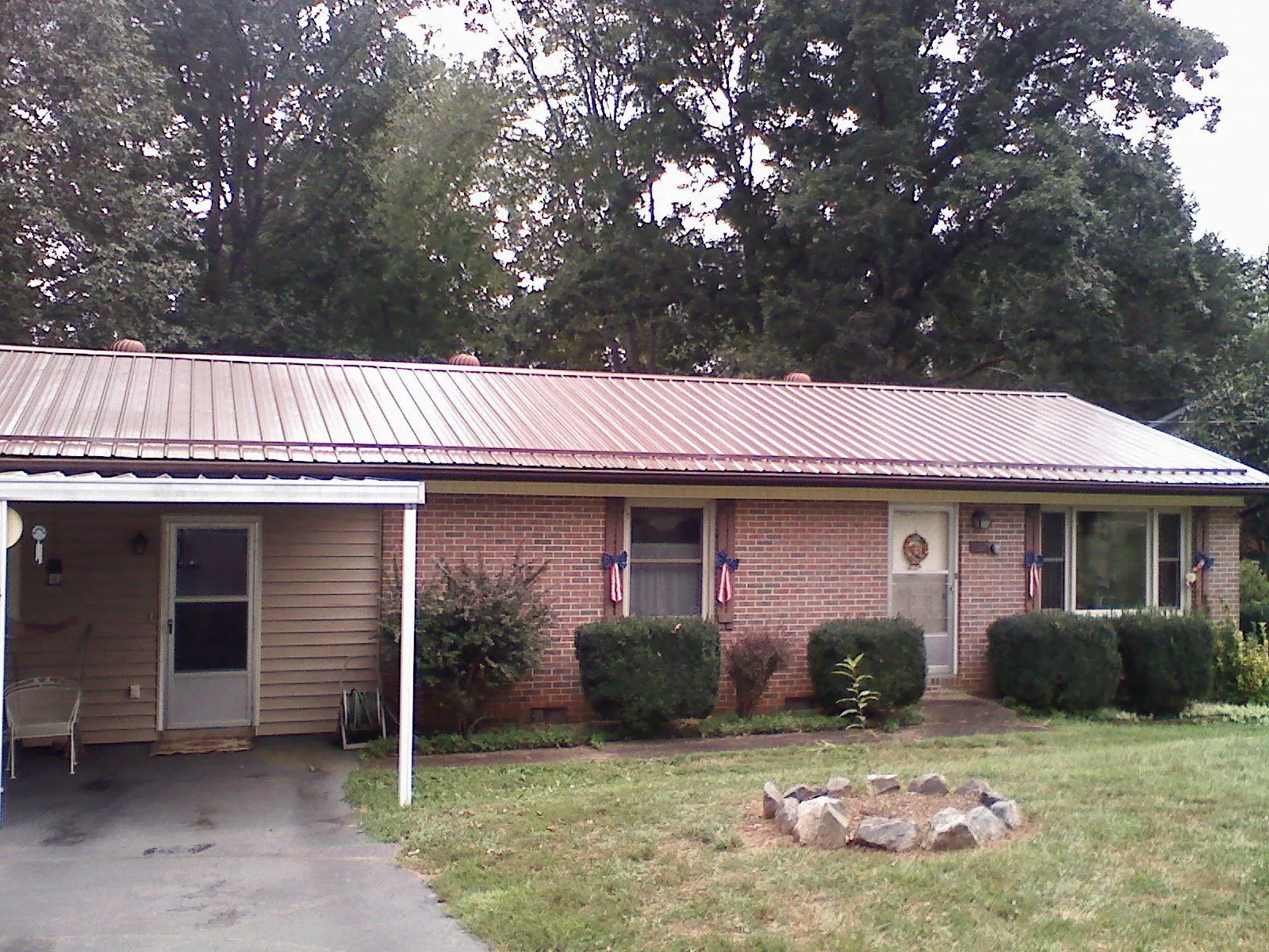 Bronze metal roof and carport on a brick ranch home — Roof Repair work by our crew in Pacific Junction